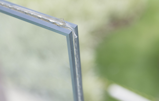 Imagem onde se vê de perto o recorte de um vidro laminado para guarda-corpo