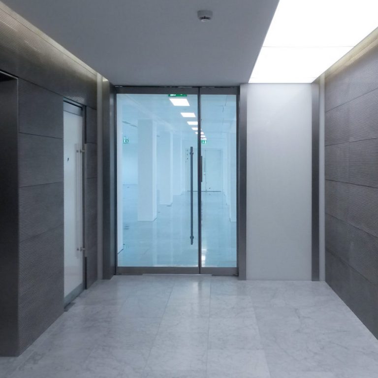 Vidraçaria Big Vidros - Imagem contendo parte de um corredor e ao fundo uma porta de vidro azulado